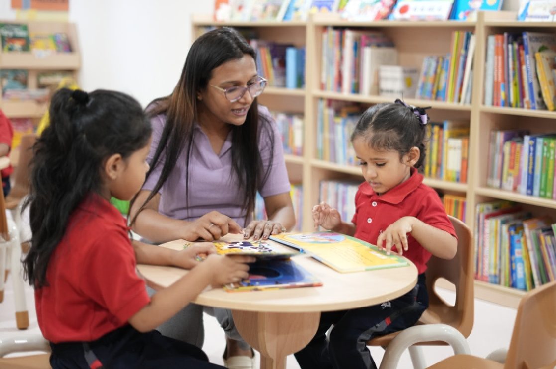An educator guiding children through a craft activity at Skill Stork ELC